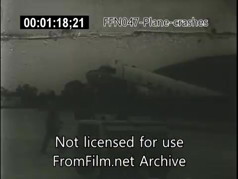 The still from 'FFN047-plane-crashes-newsreel-etc' depicts a scene involving an airplane, likely grounded or damaged, with a silhouette of a person nearby. The image has a vintage quality typical of 16mm film and includes a time code and a watermark indicating it’s not licensed for use. The overall context suggests a news segment covering aviation incidents.