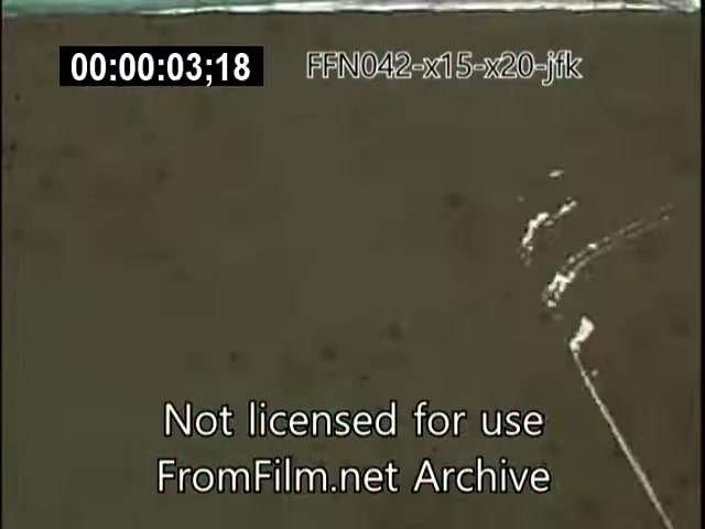 The still features a 16mm film frame indicating a timestamp of 00:00:03:18. The image appears to capture an aerial or ground-level view potentially related to the X-15 or X-20 Dynasoar programs, with a focus on the terrain or surface. The film is labeled 'Not licensed for use' and is from the FromFilm.net Archive, suggesting it's part of historical footage concerning aerospace developments or achievements, possibly tied to events involving JFK or aviation milestones like the Schneider Trophy.