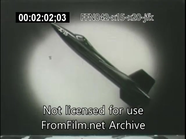 The still features a sleek, jet-like aircraft, likely the X-15 or X-20 Dynasoar, in a dramatic flight pose against a stark background. The image captures the aircraft from an angle that emphasizes its aerodynamic design. The footage is part of archival material related to aerospace exploration during the era of JFK's presidency, highlighting groundbreaking technology in aviation. The timestamp and watermark indicate it is from the FromFilm.net Archive and not licensed for use.