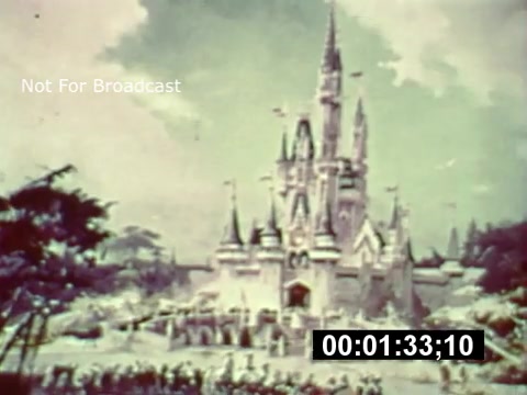 The still from the 16mm print appears to be an artistic rendering of Cinderella Castle, showcasing a whimsical and grand design typical of Disney's vision for Walt Disney World. The image captures the castle surrounded by lush greenery, evoking an enchanting atmosphere. It's marked with a timestamp, indicating its placement within a broader preview of the park during its construction phase, likely aimed at generating excitement for the upcoming attraction. The 'Not For Broadcast' label suggests this is a behind-the-scenes glimpse intended for promotional purposes.