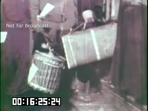 The 16mm still from 'Immigrant Heritage' features individuals appearing to carry baskets or containers, likely reflecting their experiences and struggles. The image captures a moment of labor, possibly depicting immigrant life and the challenges faced during that era. The monochromatic tones and the setting suggest a historical context, emphasizing the theme of heritage and resilience among immigrant communities.