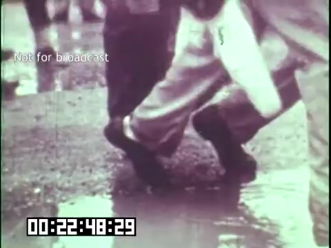 The still from 'Immigrant Heritage' features a close-up of feet walking through a puddle, suggesting movement and perhaps representing the journey of immigrants. The monochrome quality adds a historical or nostalgic feel to the scene, while the text 'Not for broadcast' indicates that this is likely a behind-the-scenes or archival shot from the educational film featuring the Irish Rovers.