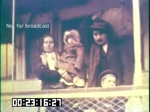 The still depicts a family standing on a porch, likely representing Irish immigrants. The group includes a woman holding a child and a man, conveying a sense of community and heritage. The setting suggests a narrative focused on immigrant experiences, possibly highlighting their struggles and resilience. The caption 'Not for broadcast' indicates that this is an unreleased or restricted image from the film.