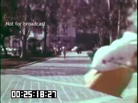 The still from *'Immigrant Heritage'* featuring the Irish Rovers depicts a vibrant street scene, likely set in a community with an Irish influence. It shows figures walking down a tree-lined boulevard, conveying a sense of activity and cultural celebration. The color palette suggests a warm, nostalgic atmosphere, characteristic of the era. A timecode at the bottom indicates the scene timing. The overlay message 'Not for broadcast' signifies that this content is for internal use only.