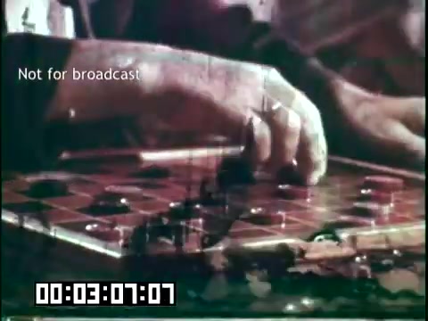 The still from 'Immigrant Heritage' features a close-up of a hand poised over a checkers board, indicating a moment of contemplation or strategy in a game. The film likely explores themes of cultural heritage and community, potentially illustrating activities that connect immigrants to their traditions and pastimes. The overlay text 'Not for broadcast' suggests that this is an unedited or restricted version meant for internal use.