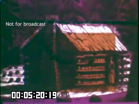 The still from the film 'Immigrant Heritage' features a rustic log cabin, depicted with a stylized, possibly animated presentation. The color scheme is vibrant, with purples and warm tones, enhancing the visual appeal. The text 'Not for broadcast' is prominently displayed, indicating that this is a restricted or behind-the-scenes clip. This scene likely serves to illustrate themes of heritage and immigration associated with the Irish Rovers.