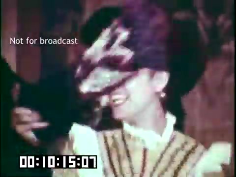 The still features a smiling woman adorned in traditional attire, presumably representing her cultural heritage. She appears to be enjoying herself, possibly during a performance or celebration, with a focus on the expressive aspects of her heritage. The muted colors and vintage quality of the 16mm film add to the nostalgic feel. The note 'Not for broadcast' indicates that this is likely a behind-the-scenes or non-commercial segment.