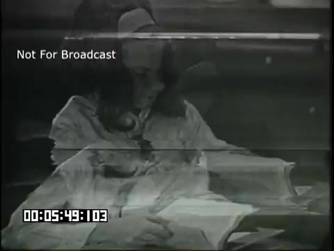 The still from the 'Sixth Grade Linguistics' educational film depicts a young girl intently reading a book. The visual quality suggests an older film format, likely a 16mm projection. There are overlay elements, including a timestamp and the label 'Not For Broadcast,' indicating it's a restricted educational content. The scene likely emphasizes engagement with language and literacy as part of the curriculum.