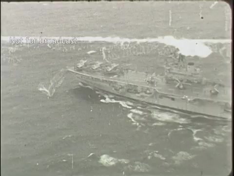 The still depicts a military aircraft carrier navigating through turbulent waters, with whitecaps visible in the ocean. The image appears aged, typical of 16mm film, and captures a moment likely related to aircraft operations or maneuvers. The watermark indicates it is not for broadcast, suggesting it is archival material.