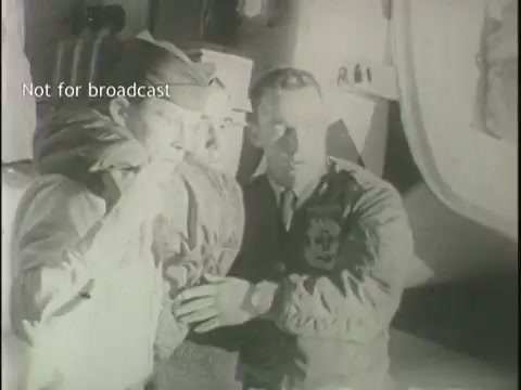 The still captures a monochromatic moment likely depicting a scene related to an aviation incident. It features two men, one in a military uniform, and the other possibly in a pilot's outfit, in a serious discussion. The setting appears tense, possibly indicating a post-crash scenario. The watermark notes that it is not for broadcast, suggesting this footage is intended for archival or licensing purposes.