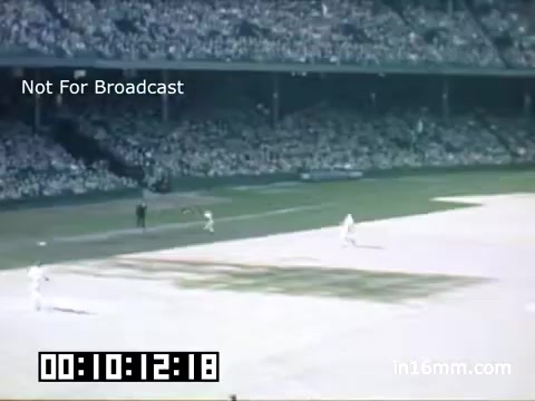 The still depicts a scene from a Detroit Tigers game at Briggs Stadium, captured on Kodachrome film between 1948 and 1950. It features a baseball field view with players in motion, likely in the midst of a play. The crowd in the stands appears to be enthusiastic, filling the background with a sea of spectators. The image conveys the lively atmosphere of a mid-century baseball game, highlighted by the iconic architecture of Briggs Stadium. The time code at the bottom indicates the length of the footage, and there's a 'Not For Broadcast' label, suggesting it's intended for archival purposes rather than public viewing.