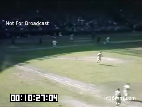 The still captures a moment from a Detroit Tigers game at Briggs Stadium between 1948 and 1950, featuring a vibrant, color scene typical of Kodachrome footage. The grass field appears bright and well-maintained, with players in uniforms actively engaged on the field. Spectators can be seen in the stands, indicating a lively atmosphere. The timestamp at the bottom suggests this is part of a longer sequence, and a watermark notes that it is not for broadcast.