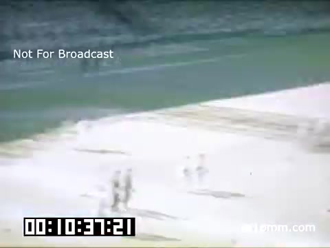 The still captures a scene from a Detroit Tigers game at Briggs Stadium between 1948 and 1950. The footage, shot in Kodachrome, depicts players on the field, likely during a game situation. The colors are vibrant, characteristic of Kodachrome film from that era. A timecode is visible at the bottom, indicating the moment captured. The 'Not For Broadcast' label suggests this footage was likely not intended for public airing. The overall ambiance conveys a sense of nostalgia for mid-20th century baseball.