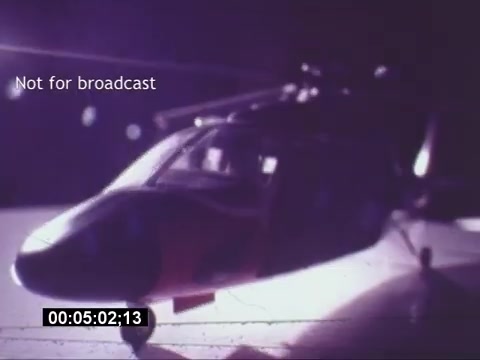 The still from the 'Sikorski S-76 Promotional Film' features a model of the Sikorski S-76 helicopter, captured in dramatic lighting that highlights its sleek design. The helicopter model appears to be positioned on a reflective surface, contributing to an enhanced visual effect. Overlay text states 'Not for broadcast,' indicating that the image is meant for private use. The timecode in the corner suggests this is a specific moment within the film, enhancing its context as a promotional asset.