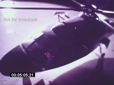 The still from the 'Sikorski S-76 Promotional Film' features a close-up view of a Sikorsky S-76 helicopter. The image highlights the sleek design and features of the aircraft, with visible rotor blades in the background. The lighting suggests a dramatic or promotional context, emphasizing the helicopter's features. Text overlay indicates that the content is not for broadcast, and a timecode is displayed at the bottom. Overall, the still captures the essence of an aviation promotional material.