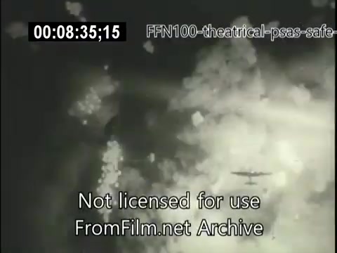 The still from the 1949 theatrical public service announcements for safe driving features an aerial view, likely depicting a scene with clouds or smoke, and possibly an aircraft in the frame. The monochrome image conveys a dramatic tone, hinting at themes of caution and awareness, typical of public service messages aimed at promoting safe driving behaviors. The timestamp and copyright notice suggest it's part of a larger archival piece.