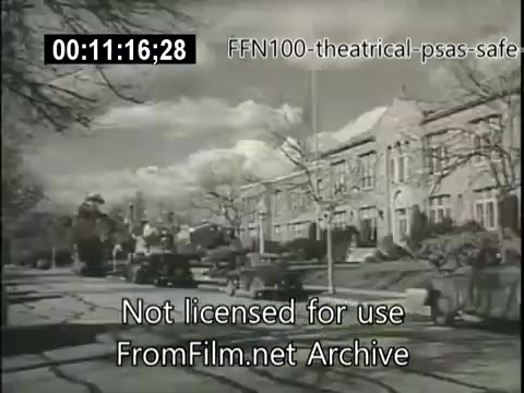 The still features a black-and-white image from a 16mm film focused on safe driving, dating from 1949. It depicts a suburban street scene with classic cars parked along the curb and residential buildings in the background. The sky is partly cloudy, contributing to a nostalgic atmosphere. The image includes a watermark indicating it's from the FromFilm.net Archive.