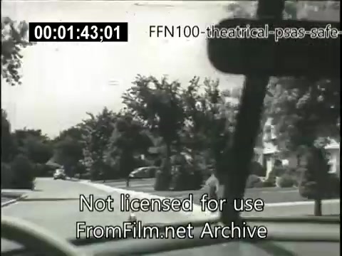 The still shows a black-and-white view from inside a car, capturing a suburban street with trees and houses. The image is part of a 1949 theatrical public service announcement focused on promoting safe driving. A time code is displayed at the top, and a watermark indicates it's not licensed for use. The overall tone reflects the era's emphasis on road safety.