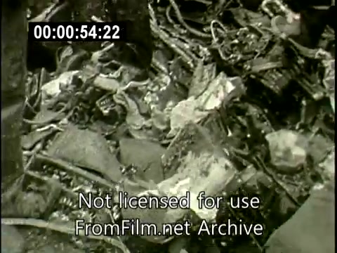 The still captures the aftermath of the Staten Island plane crash from December 16, 1960, focusing on the wreckage of the Lockheed Constellation aircraft N6907C. The image shows a chaotic scene of debris, twisted metal, and fragments scattered across the ground, indicative of a severe mid-air collision. This United Press footage serves as a stark reminder of the tragic event and its impact.