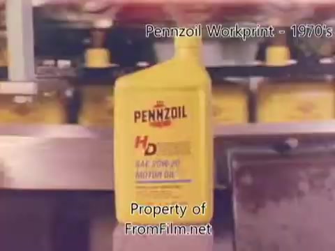 The still from the 'Pennzoil Factory/Refinery Workprint - 1980's' features a close-up of a yellow Pennzoil bottle prominently displaying the 'HD' label, suggesting a focus on motor oil. In the background, out-of-focus bottles and machinery hint at a busy refinery environment. The film shows some debris in the gate, indicating age or wear, consistent with its 16mm workprint format. Accompanying music is from Underbelly, providing an atmospheric backdrop to the visual content.