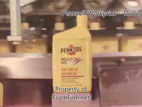 The still from the 'Pennzoil Factory⧸Refinery Workprint - 1980's' features a close-up of a yellow Pennzoil motor oil bottle labeled 'MULTI-VIS SAE 10W-30.' The background suggests a factory setting, with machinery visible, highlighting the oil production process. There are signs of debris in the film gate, a common issue in vintage film prints. The accompanying music from Underbelly sets a nostalgic tone, complementing the industrial imagery of the workprint.