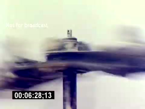 The still from the 'USMC Aviation Ordnance Recruiting Film - Silent' depicts a dynamic motion shot, likely showcasing a rotating mechanism or component, possibly an aircraft part or weaponry being tested. The blurred motion suggests high speed, emphasizing the engineering and technology involved in aviation ordnance. The background is muted, drawing focus to the subject's movement. The timecode indicates it's a segment from a longer film.