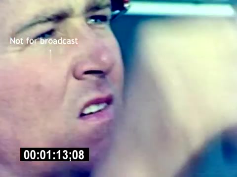 The still from the 'USMC Aviation Ordnance Recruiting Film - Silent' shows a close-up of a male service member’s face, capturing a moment of intensity or focus. He appears to be in a dynamic environment, likely related to aviation or ordnance operations, given the context of the film. The image suggests a sense of determination and engagement in his role. The timestamp indicates the moment within the film, and a watermark stating 'Not for broadcast' is present.