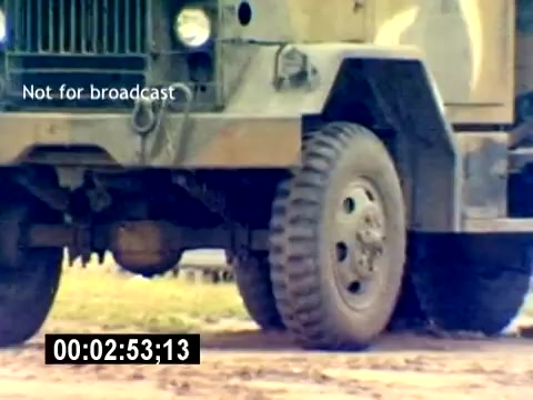 The still shows a military vehicle, likely a truck, with a close-up on its front wheel and axle. The vehicle has a rugged, camouflaged exterior and is positioned on a dirt or gravel surface, indicating use in a field environment. The text 'Not for broadcast' suggests it's part of a training or promotional film, and the timestamp indicates its place in the clip. The overall focus appears to be on military operations and logistical support related to ordnance.