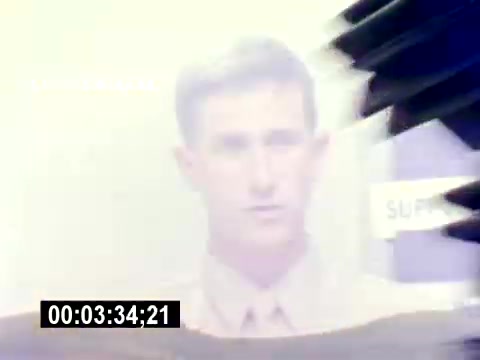 The still shows a blurry image of a young man in military attire, likely a Marine, with a neutral expression. The background appears light and somewhat obscured, possibly indicating motion or a transition. There are text elements partially visible, including the word 'SUPERVISOR.' The overall tone seems to suggest a focus on military personnel, fitting the context of a recruiting film.