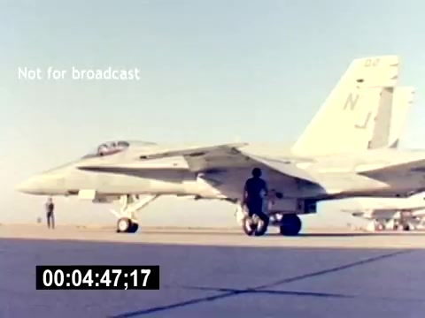 The still features a military aircraft, specifically a fighter jet, situated on a runway under clear skies. In the foreground, a service member is seen working near the aircraft, while another figure is further back, indicating an active aviation environment. The image is marked 'Not for broadcast,' suggesting it is intended for internal or specific use rather than general media distribution. The timecode at the bottom indicates the moment within the film. Overall, it captures the essence of military aviation recruitment, showcasing the technology and personnel involved.