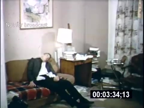 The still from 'College Days - 1956' shows a disheveled room with a man slumped on a couch, appearing to be in a relaxed or perhaps exhausted state. The setting includes a cluttered desk with books and a lamp, along with a patterned curtain. The overall ambiance hints at a casual, possibly student lifestyle.