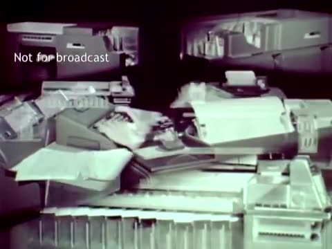 The still from 'IBM - The Information Center' (1963) showcases a collection of IBM technology, including various computer hardware components and punch cards. The image emphasizes the innovative use of these technologies in managing educational tasks such as grade tracking and course enrollment, highlighting the era's advancements in computing. The monochromatic and technical aesthetic reflects the film's focus on the capabilities of IBM technology at the time.