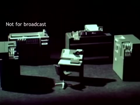 The still features a dimly lit arrangement of vintage IBM computing hardware, including a mainframe, printers, and peripheral devices, highlighting the technology of the early 1960s. The equipment exemplifies IBM's role in automating educational processes, such as managing grades and course enrollments through punch cards. The text 'Not for broadcast' suggests this may be a behind-the-scenes or promotional image, emphasizing the focus on technology rather than a public presentation.
