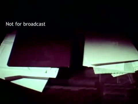 The still from 'IBM - The Information Center' features a dimly lit arrangement of documents and folders, likely representing educational records and punch cards. The focus on physical materials highlights the contrast between traditional paper-based processes and emerging computer technology in the 1960s, emphasizing IBM's role in streamlining educational administration through innovative software solutions. The overlay text 'Not for broadcast' indicates that this material is not intended for public dissemination.