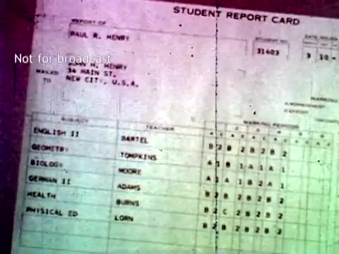 The still depicts a student report card from the 1960s, showcasing IBM's computer technology in educational settings. It includes the student's name, address, and a list of subjects with corresponding grades, highlighting the use of paper records common at the time, such as punch cards, facilitating grading and course enrollment. The design reflects the era's standard format for academic reporting, illustrating the intersection of technology and education.