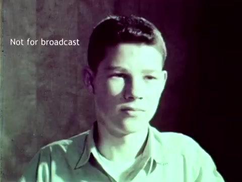The still depicts a young boy with a serious expression, set against a simple background. The film is labeled 'Not for broadcast,' indicating it is likely intended for educational or internal purposes. Contextually, the film showcases IBM's computer technology from 1963, highlighting its applications in managing grades and course enrollments, as well as addressing educational needs through innovative processes like punch cards.
