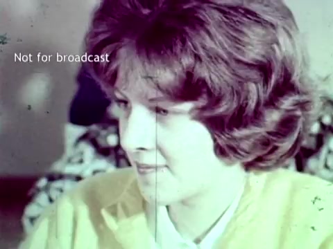 The still from the 1963 IBM film features a close-up of a woman with wavy hair, focused intently on a task. The image is colored with a vintage tint, typical of that era's film processing. A text overlay reads 'Not for broadcast,' indicating that the footage is intended for internal use only. The context suggests this woman is likely engaged in a demonstration or discussion related to IBM's technology for managing educational data like grades and course enrollments, featuring tools like punch cards.