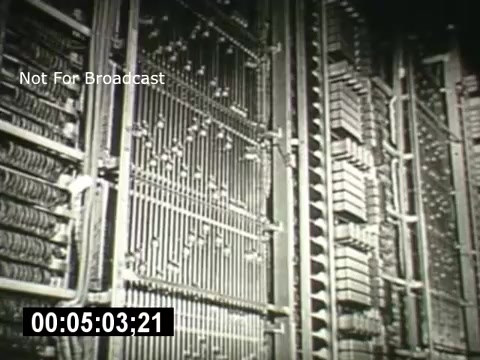 The still from 'Bell System - Story Without End' features a close-up view of intricate telecommunications hardware, showcasing a complex array of wires and connections. The image conveys the advanced technology of the Bell System, emphasizing the engineering involved in telephone systems. The frame includes a timestamp and a disclaimer indicating it is not for broadcast.