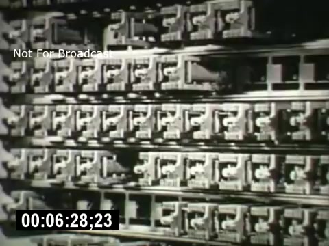 The still from 'Bell System - Story Without End' shows a close-up view of multiple telephone switchboards or relays arranged in rows. The image highlights intricate mechanical components, showcasing the technology used in telecommunication systems. The film likely explores the evolution and importance of telecommunications infrastructure. A timecode is visible, indicating the specific moment in the film.
