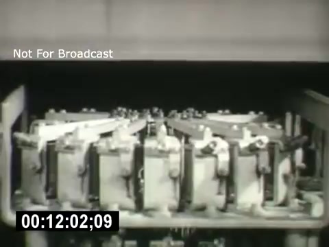 The still depicts a close-up of various mechanical devices within a telecom system, likely relays or switches. It emphasizes the intricacy of Bell System technology, showcasing how interconnected components work together. The image is likely from an educational or promotional film highlighting advancements in telecommunications. The timestamp indicates it is a part of a larger sequence.