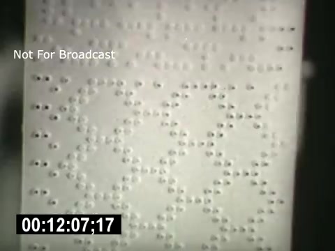The still features a close-up of a perforated paper with a grid-like pattern, likely illustrating an early telecommunications or data recording method. The text 'Not For Broadcast' indicates that this is a private or restricted piece of media, and the timestamp suggests a specific moment in the film 'Bell System - Story Without End,' which discusses the history and impact of telephone technology.
