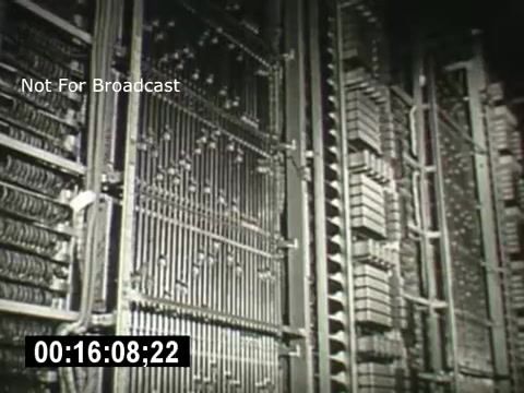 The still depicts a close-up view of intricate telephone switching equipment used by Bell System. The dimly lit image highlights numerous wires and metal components, demonstrating the complexity of early telecommunications technology. A timestamp at the bottom indicates the specific moment within the film. The label 'Not For Broadcast' suggests it’s intended for restricted viewing.
