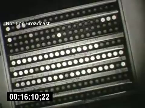 The still from 'Bell System - Story Without End' features a close-up view of a control panel or switchboard, showcasing rows of buttons or lights. The monochromatic color scheme suggests a dated, industrial aesthetic typical of mid-20th-century technology. The image conveys a sense of complexity and functionality, relevant to telecommunications. A timestamp indicates its position within the film, while a watermark states 'Not For Broadcast.'