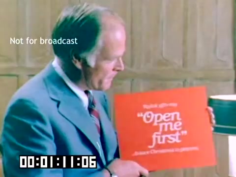 The still features a man in a blue suit, holding a bright red sign that reads 'Open me first.' The background appears to be a simple office or meeting space. The text 'Not for broadcast' is visible in the corner, indicating that this is not intended for public viewing. The timestamp on the bottom suggests the film is approximately one minute and eleven seconds in. The overall presentation suggests a promotional or instructional context typical of corporate sales material from the late 1970s.