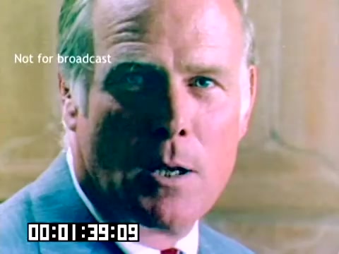 The still features a close-up of a man in a suit, focused intently on the camera. His expression suggests a sense of urgency or importance, enhancing the promotional tone of the piece. The background is somewhat blurred, likely emphasizing the subject. The overlay indicates it's not meant for broadcast, and there’s a timecode displayed at the bottom.