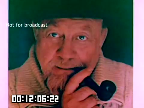 The still features a close-up of an older man with a thoughtful expression, holding a pipe near his mouth. He has light-colored hair and is wearing a cozy sweater. The background has a colorful hue, adding a vintage feel typical of the 1970s. A 'Not for broadcast' label is visible, along with a timecode in the bottom corner. The image appears to be from a Kodak sales film, showcasing a nostalgic moment.