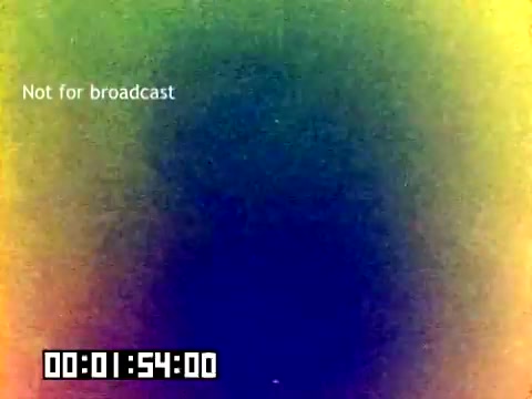 The still features a colorful gradient, mostly blending shades of blue, green, yellow, and orange. A 'Not for broadcast' watermark is present in the top left corner. A timestamp in a digital format shows '00:01:54:00' at the bottom. The image appears to be a screen capture from a 16mm film, likely indicating an introductory or transition segment of the silent Kodak sales film from 1977.