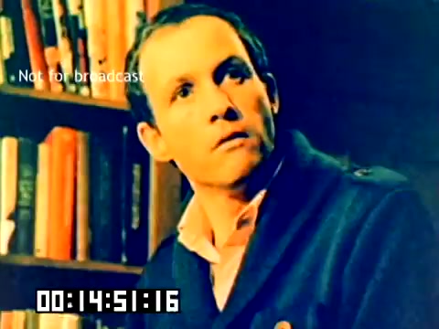 The still from the 'Silent Kodak sales film from 1977' features a man with a serious expression, wearing a navy blue jacket over a collared shirt. He appears to be in a room filled with books, suggesting an intellectual or contemplative setting. The frame indicates it is not for broadcast and includes a timecode. The overall color tone has a vintage feel typical of the era.