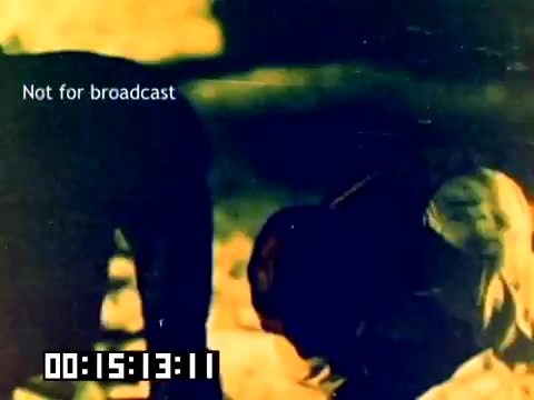 The still features a blurred scene likely depicting Dick Van Dyke and Michael Landon, among others, potentially engaging in an outdoor activity, such as filming or demonstrating using Kodak products. The image has a warm, golden hue characteristic of the 1970s film quality, and prominently displays a 'Not for broadcast' watermark, along with a timestamp indicating the footage's position. The overall atmosphere conveys a nostalgic vibe, reflective of the era's marketing approach for film products.