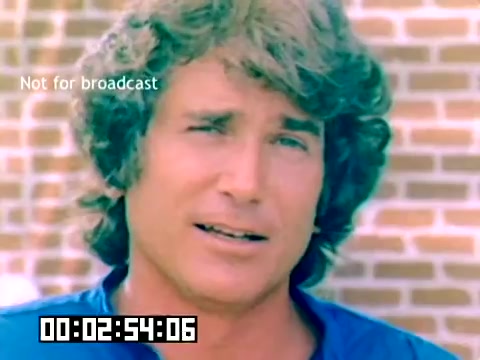 The still depicts a young Michael Landon, known for his distinctive wavy hair and engaging expression. He appears to be speaking directly to the camera, conveying an approachable and personable demeanor. The background features a brick wall, offering a nostalgic 1970s aesthetic. The timestamp in the bottom corner suggests it's part of a recorded segment, while the watermark indicates it is not intended for public broadcast.